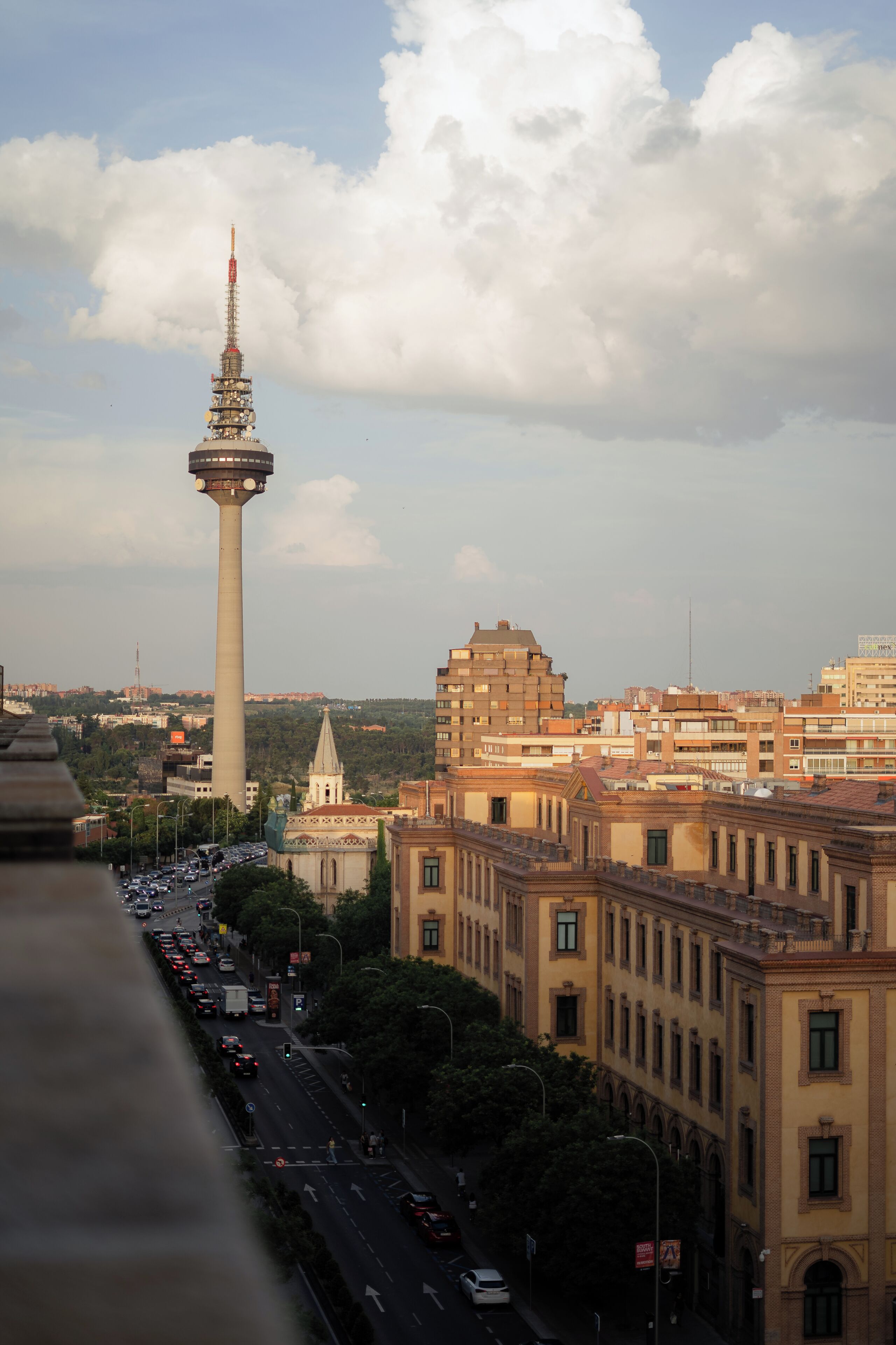 Un paisatge urbà amb una torre destacada, un carrer animat i edificis històrics.