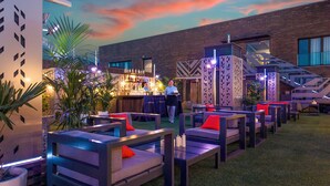 Un espace extérieur aménagé avec des meubles modernes, un bar et un escalier.