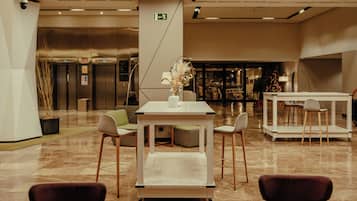 A lobby with a central table, seating, and a Christmas tree.