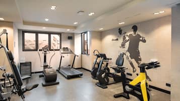 Un gimnasio con cintas de correr, elípticas y bicicletas estáticas.