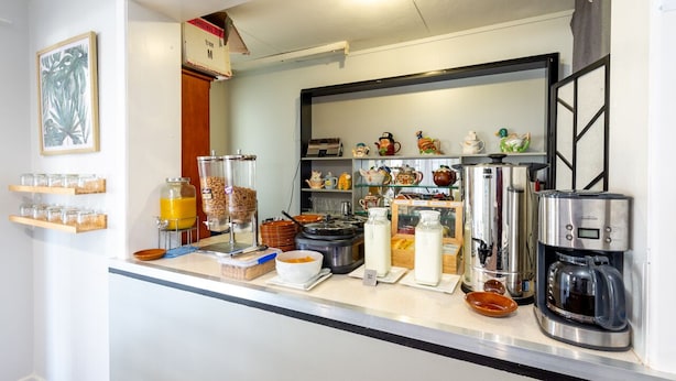 A breakfast bar with various food items and a coffee machine. - Riviera on Ruthven Motel (South Toowoomba)