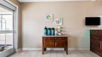 Una cocina con una mesa de madera, un televisor y obras de arte en la pared.