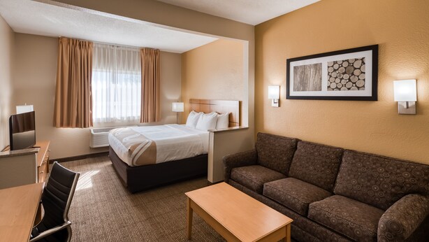 Een hotelkamer met een bed, een bank, een bureau en een stoel.