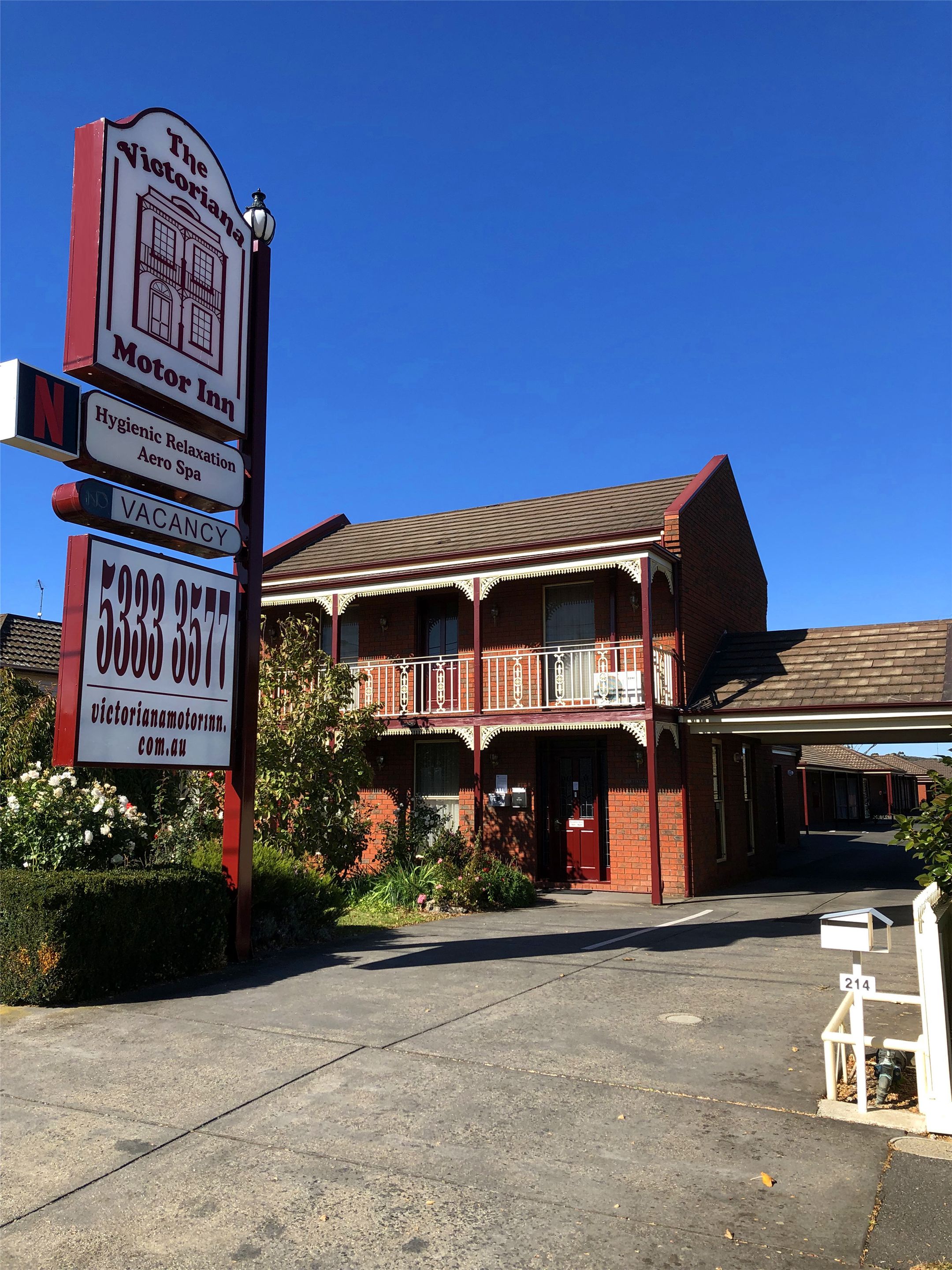 A Victorian Motor Inn with a prominent signboard, a two-story brick building, and a balcony.