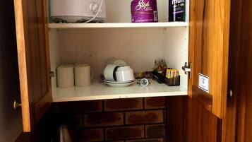 Une cuisine équipée d’un grille-pain, d’un paquet de papier toilette et d’une machine à café posée sur le comptoir.