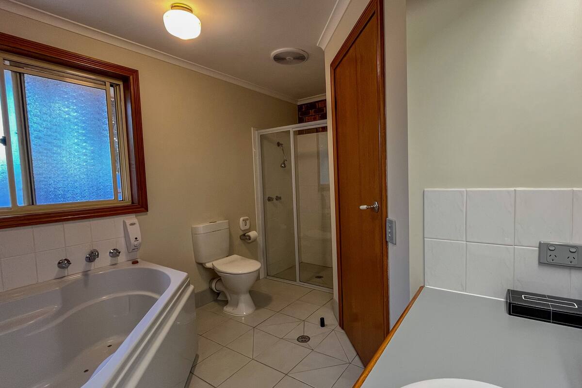 A bathroom with a bathtub, toilet, and shower.