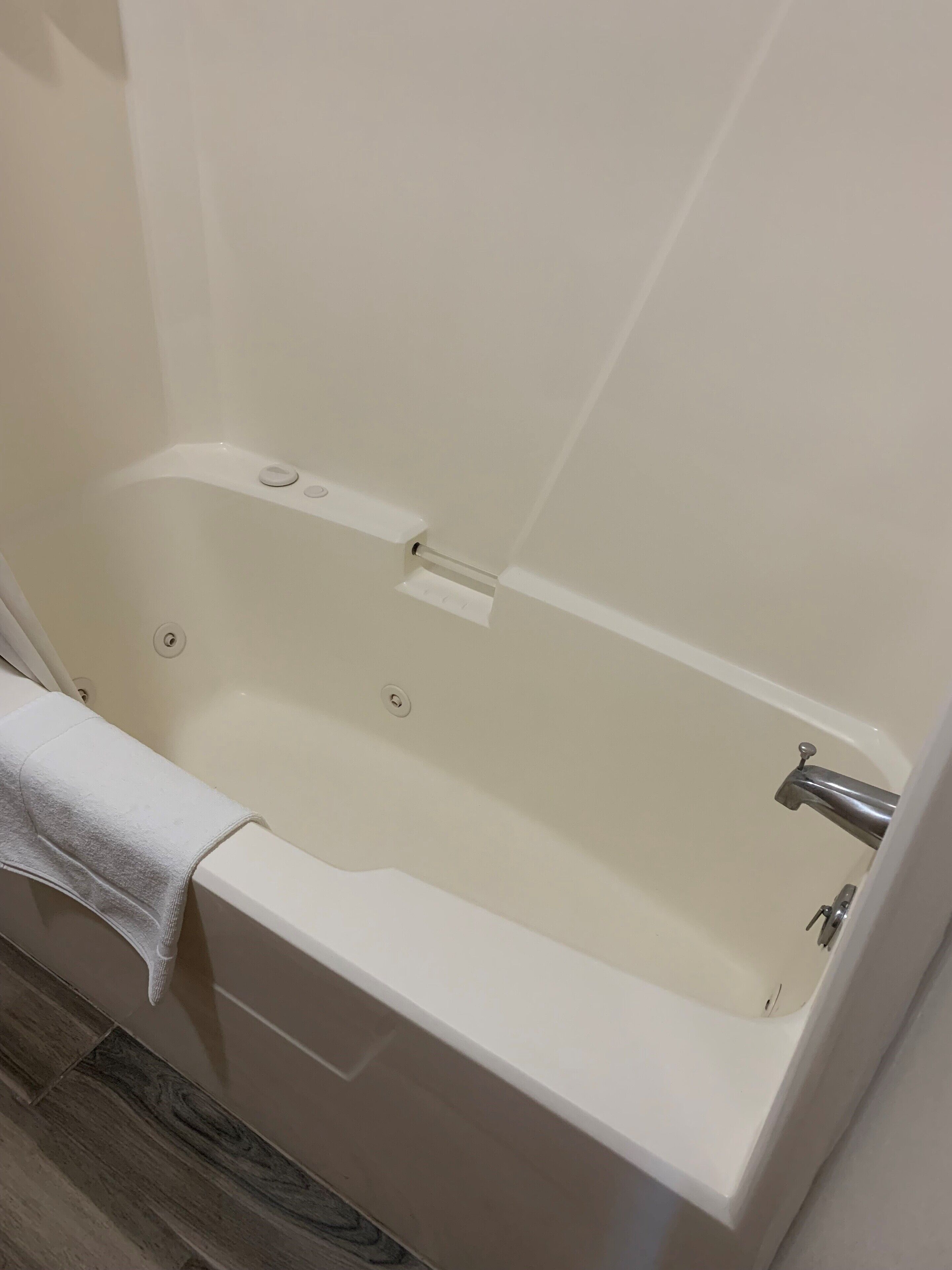 Una bañera con una toalla, un grifo y un panel de control.