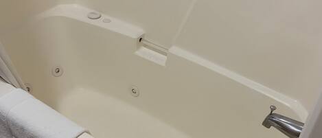 Una bañera con una toalla, un grifo y un panel de control.