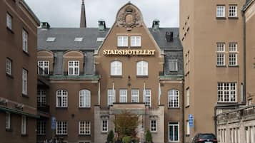 A historic building with the name "Stadshotellet" prominently displayed. It features a symmetrical facade with a central entrance, multiple windows, and a decorative crest above the entrance.