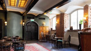 A cozy dining area with wooden furniture, a patterned rug, and brick walls. - Elite Stadshotellet Västerås (Vasteras)