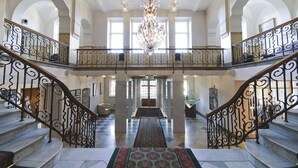 A grand staircase with ornate railings leading to a second floor, a chandelier, and a patterned carpet. - Elite Stadshotellet Västerås (Vasteras)