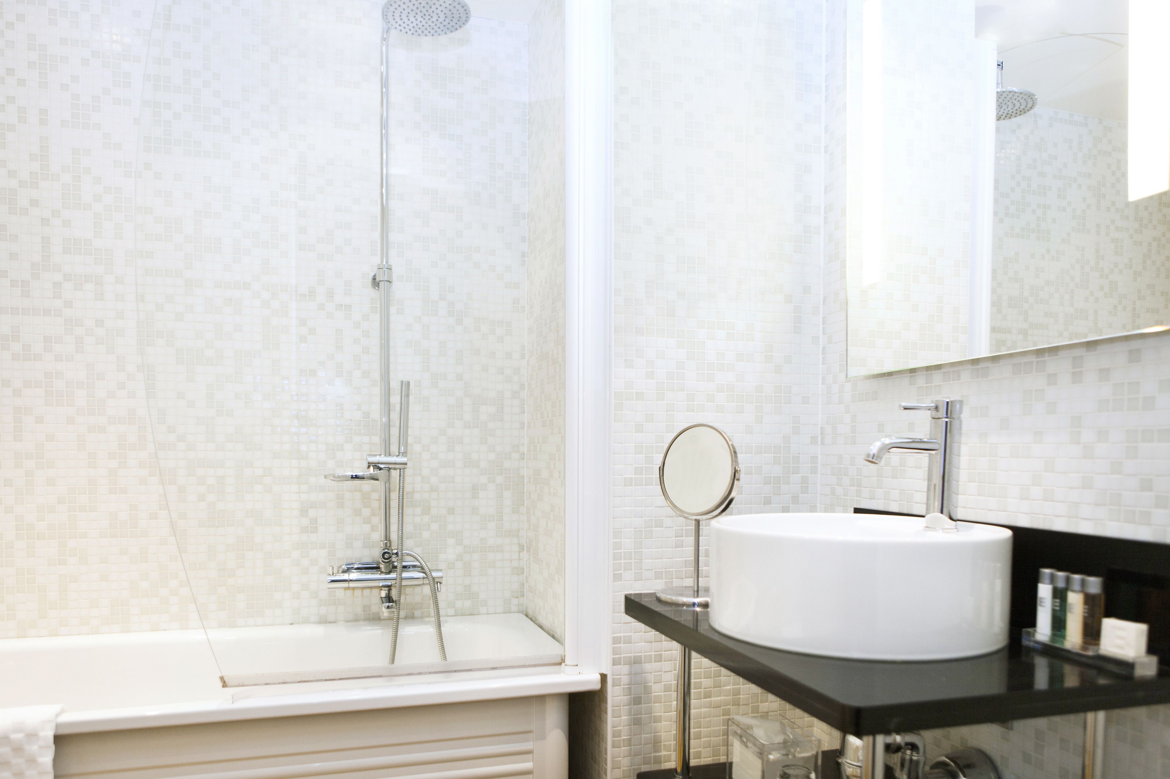 Une salle de bain moderne avec une douche, un lavabo et un miroir.