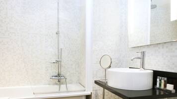 Une salle de bain moderne avec une douche, un lavabo et un miroir.