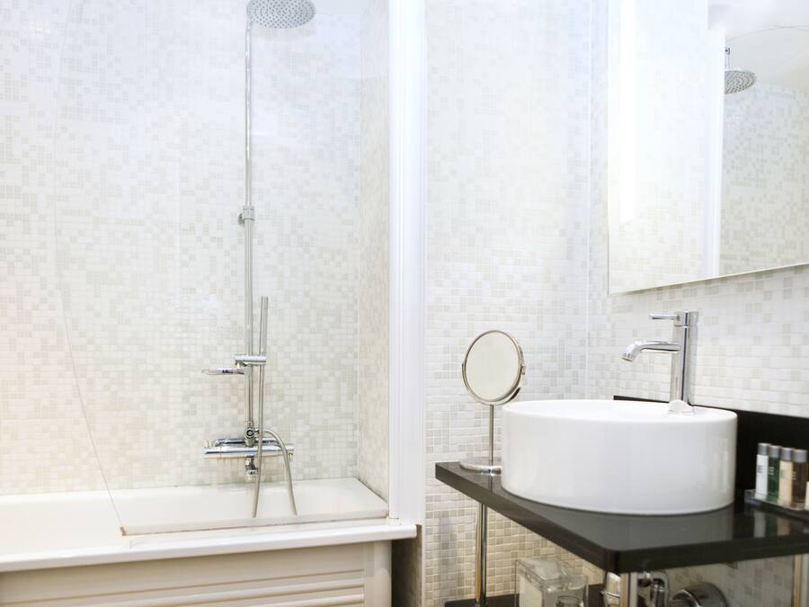 Une salle de bain moderne avec une douche, un lavabo et un miroir.