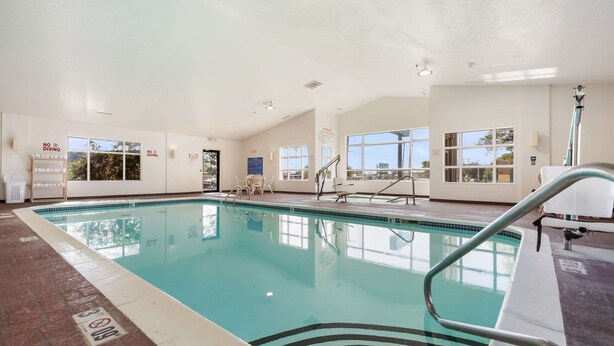 An indoor swimming pool with clear water, a tiled floor, and a pool ladder. - Quality Inn Lincoln Cornhusker (Lincoln)