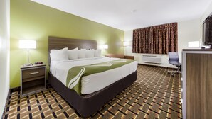 A hotel room with a bed, bedside tables, a desk, and a television. - Quality Inn Lincoln Cornhusker (Lincoln)