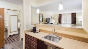 A modern kitchen with a granite countertop, stainless steel sink, and a mirror above the counter. - Quality Inn Lincoln Cornhusker (Lincoln)