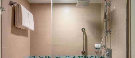 Ducha con cabezal de ducha de mano, control de ducha manual y puerta de vidrio.