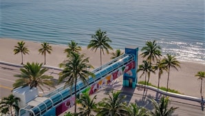 A beachside walkway with palm trees and a view of the ocean.