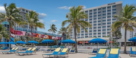En la playa, sillas reclinables de playa, sombrillas, toallas de playa