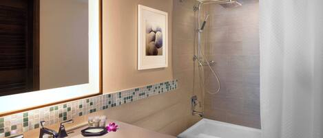 Une salle de bain avec un lavabo, un miroir, une douche et un tableau encadré au mur.