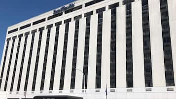 A tall, modern building with a prominent sign at the top reading "Capital City Hotel."