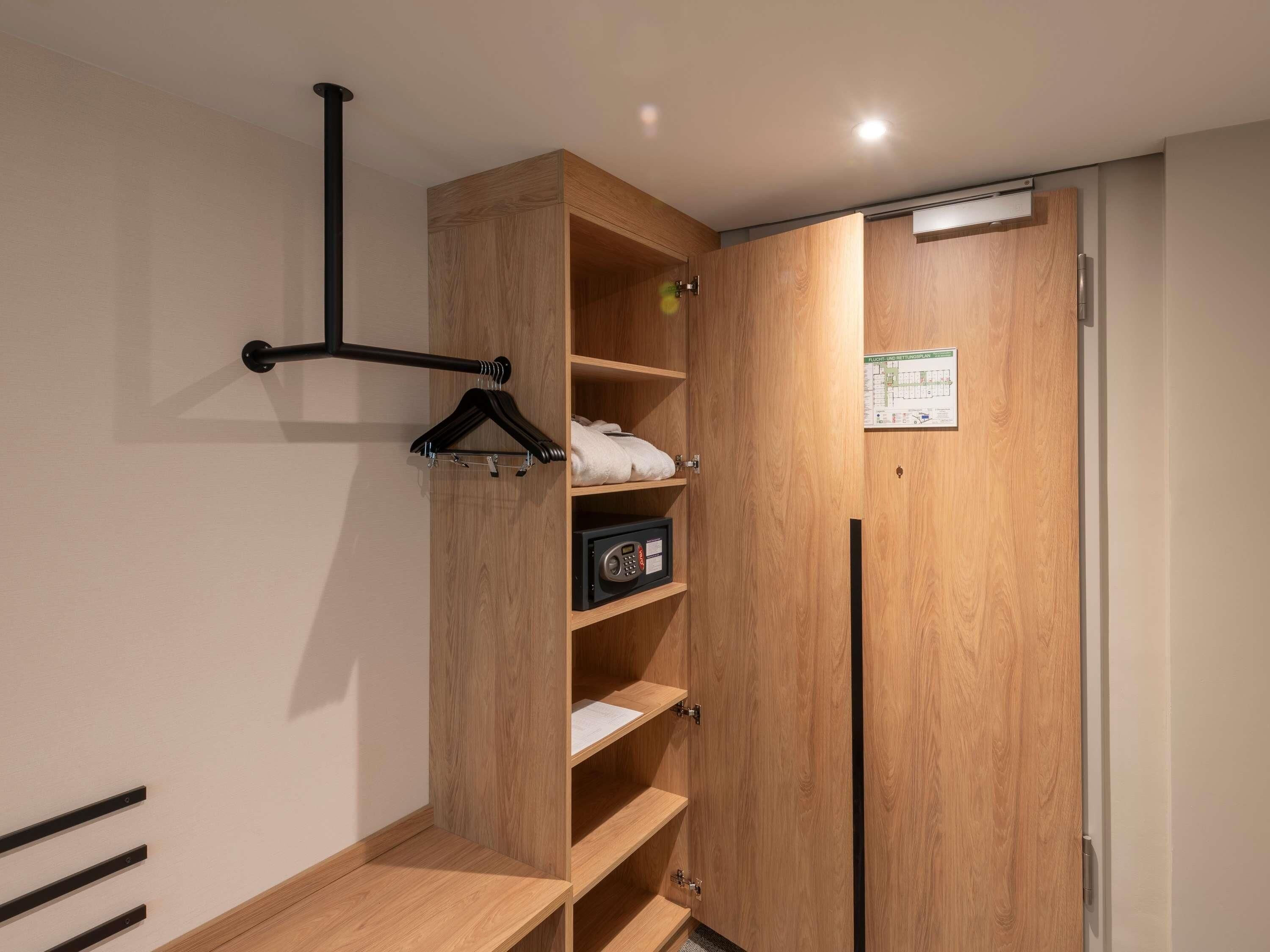 Ein Holzschrank mit mehreren Einlegeböden, einer Kleiderstange und einer Tür mit einer Karte.