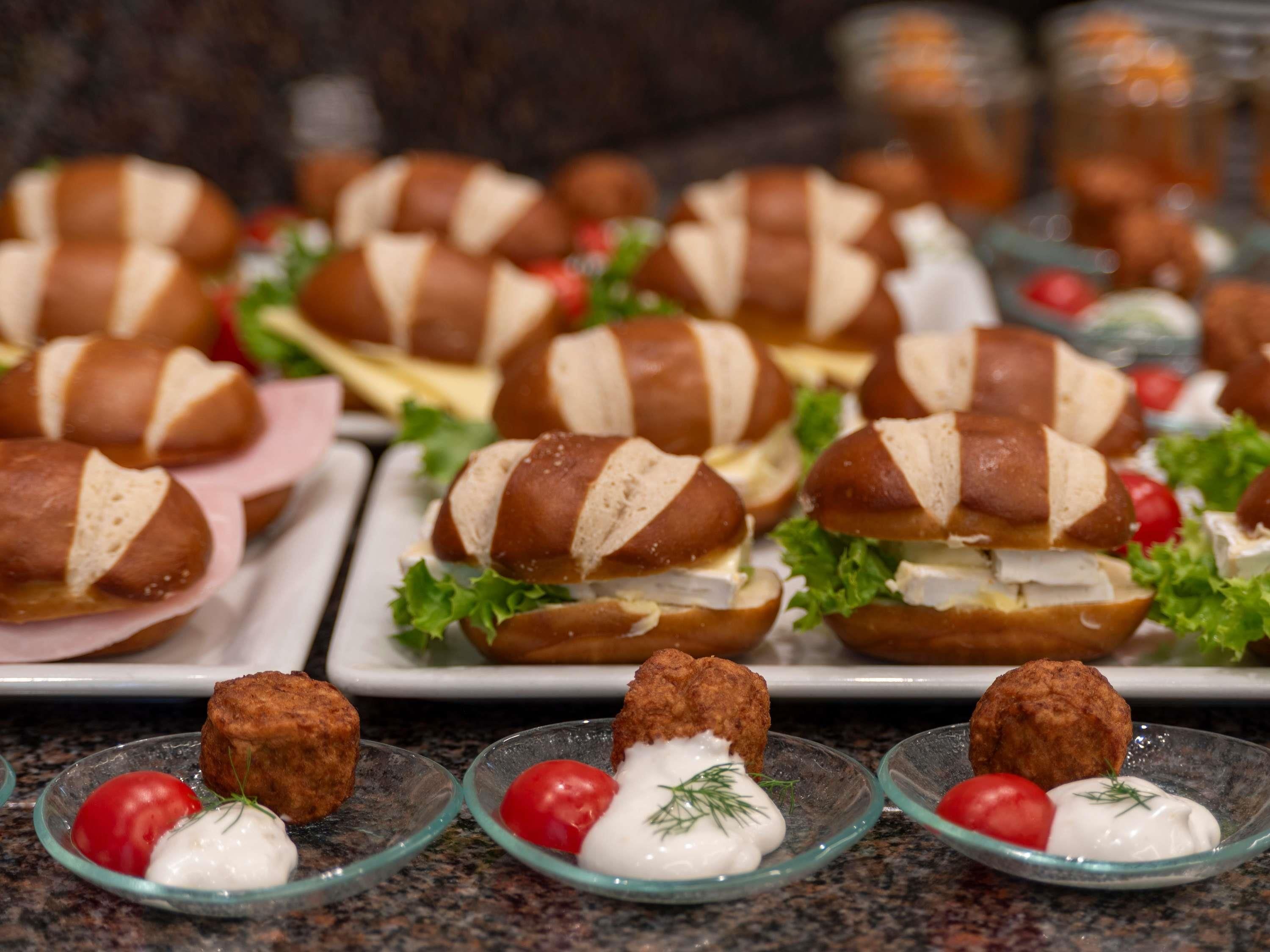 Een buffet met belegde broodjes en kleine bakjes dipsaus.