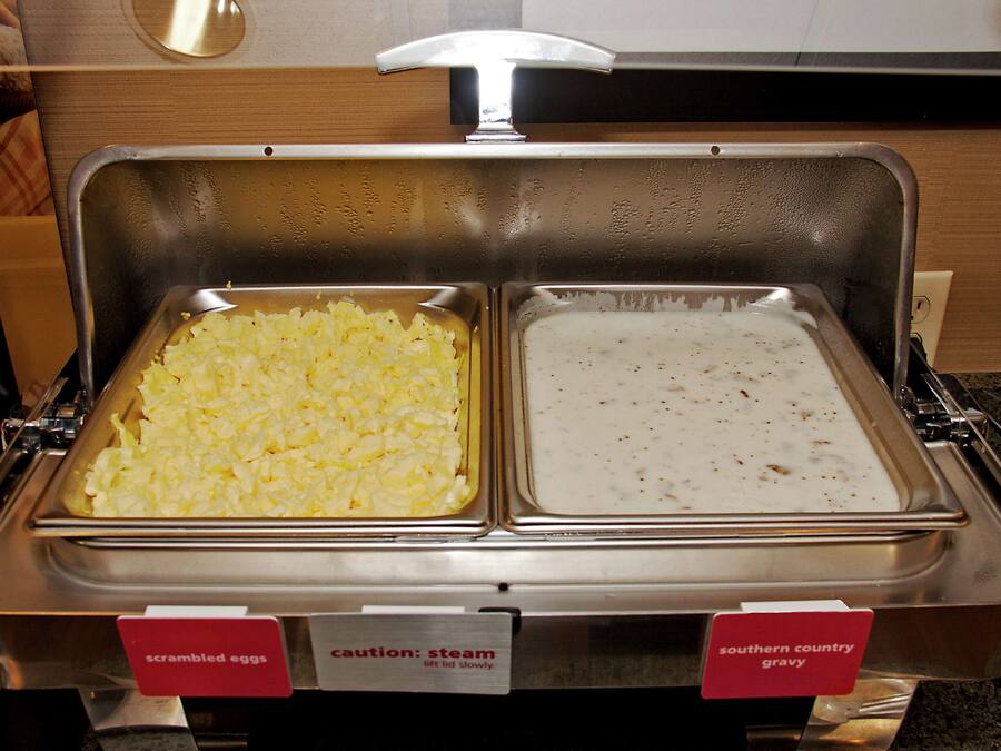 Een buffet met roerei en zoete jus.
