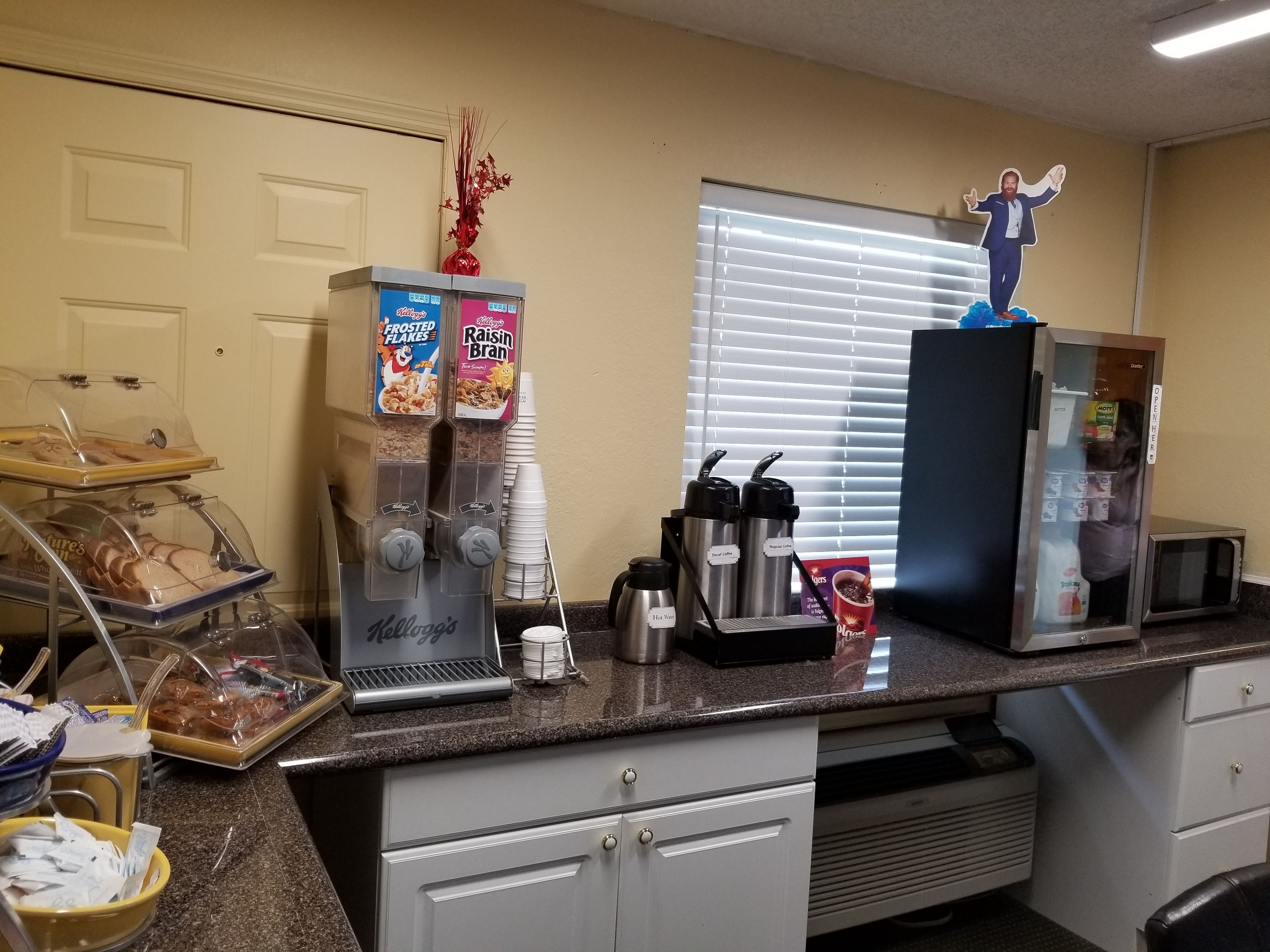 A kitchenette with a coffee machine, a refrigerator, and a microwave.