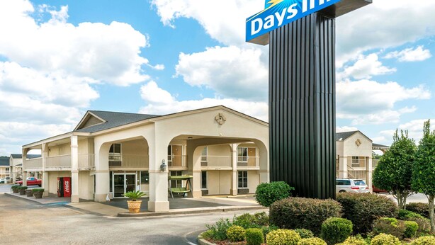 A Days Inn hotel with a prominent sign, a two-story building, and a parking lot. - Days Inn by Wyndham Shorter (Shorter)