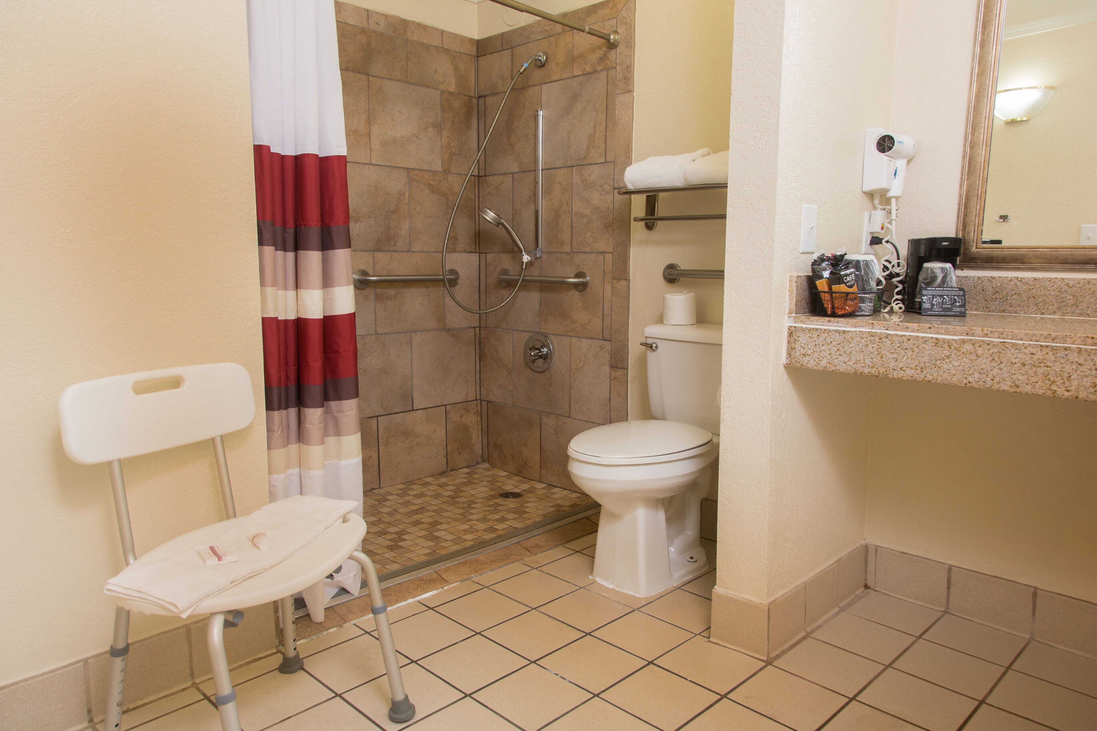 Rom – deluxe, 1 kingsize-seng, tilgjengelighetstilpasset, ikke-røyk (Roll-In Shower) | Bad | Kombinert dusj/badekar, toalettartikler (inkludert) og hårføner