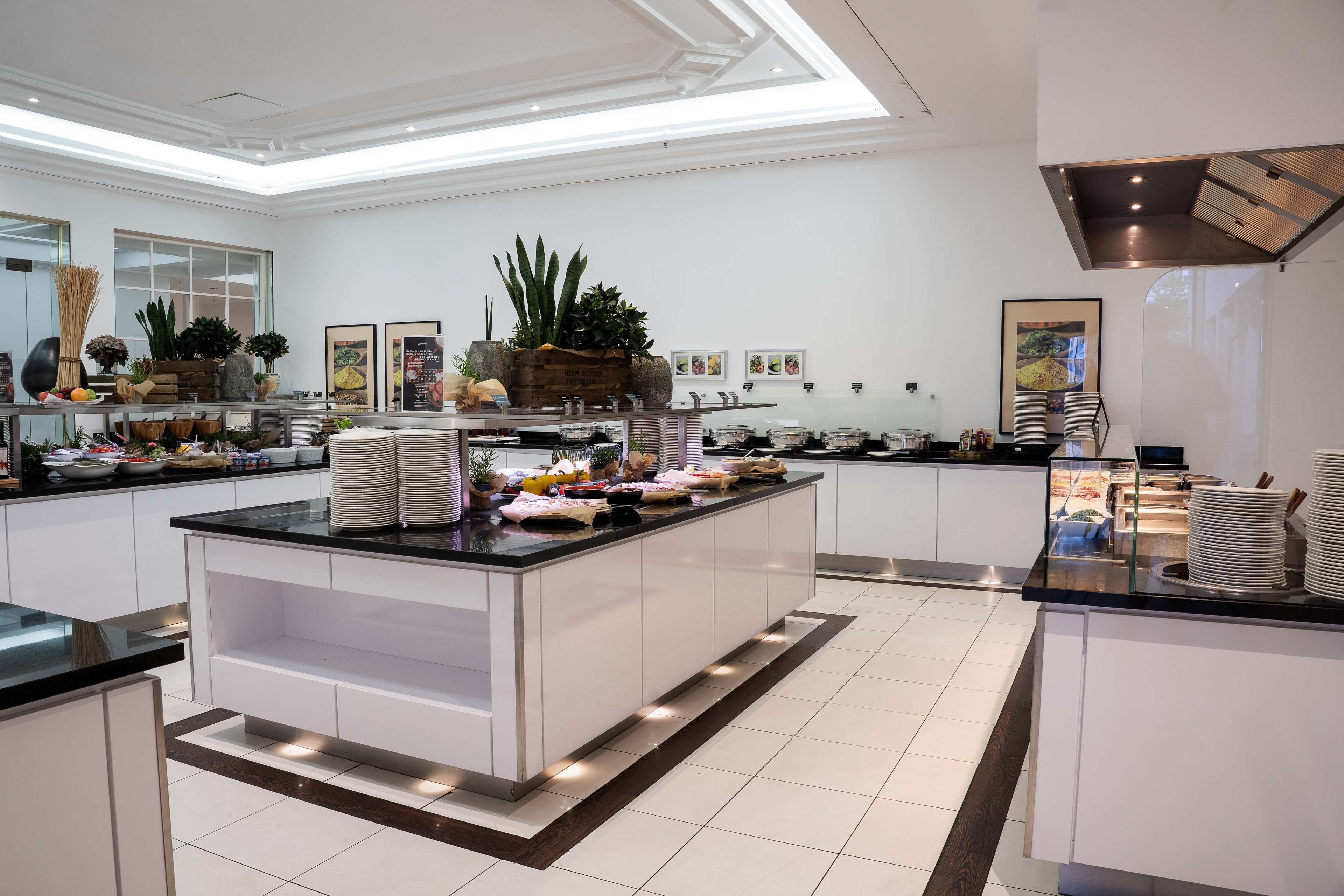 A modern kitchen with a central island, white cabinetry, and various food items displayed.