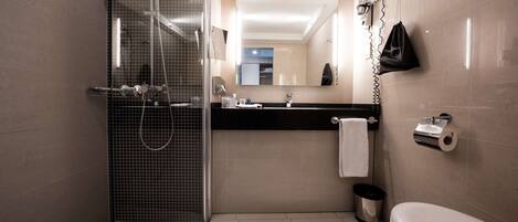 A modern bathroom with a shower, toilet, and sink.