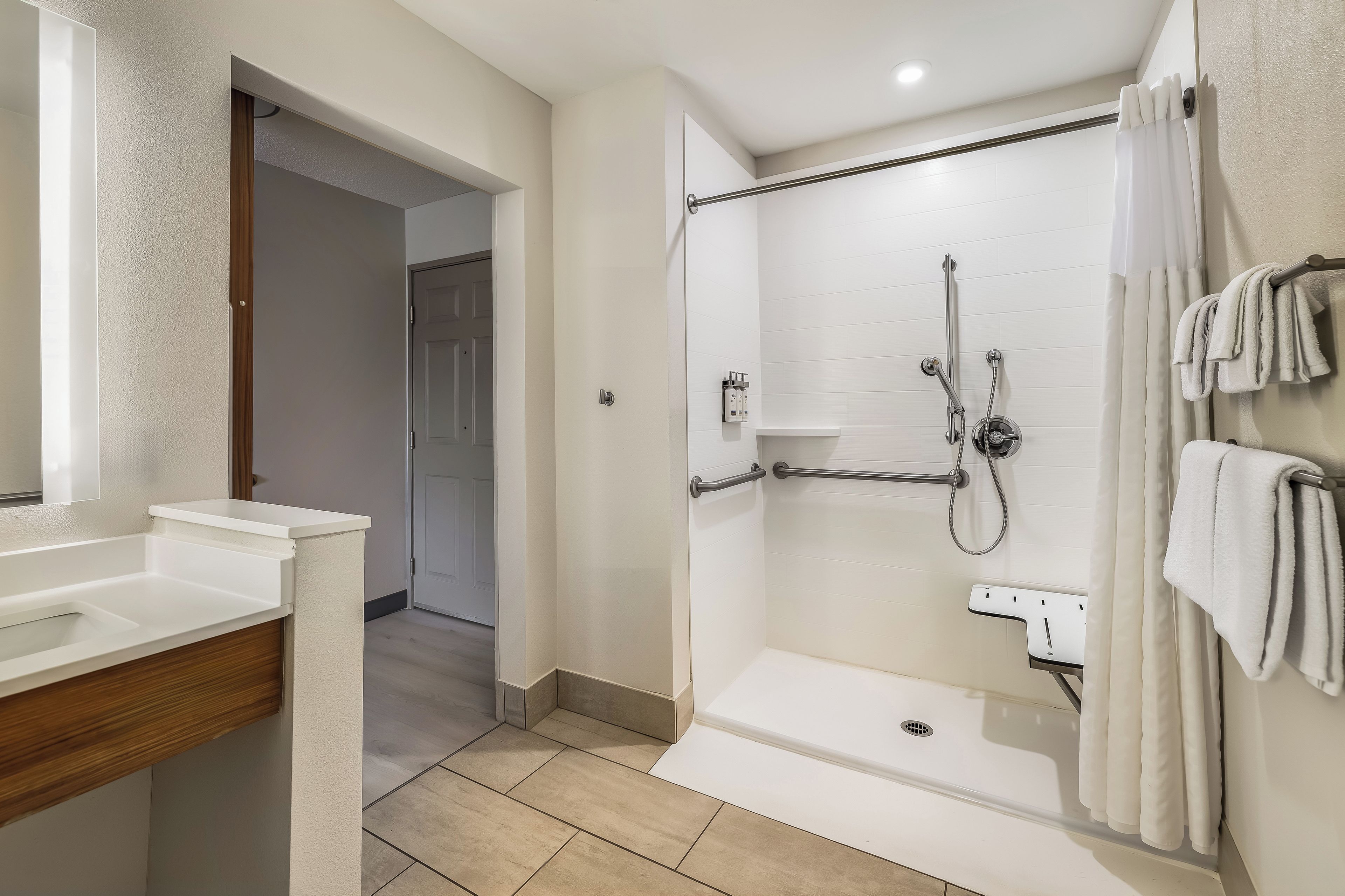 A modern bathroom with a walk-in shower, a toilet, and a sink.