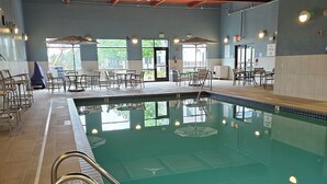 An indoor swimming pool with clear water, surrounded by tiled walls and a wooden floor. - Holiday Inn Express & Suites Minneapolis – West End by IHG (Golden Valley)