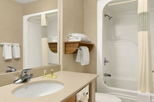 Une salle de bain avec un lavabo, un miroir et une baignoire.