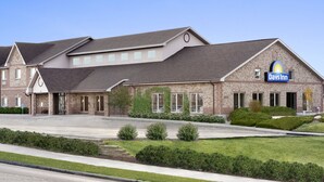 A Days Inn hotel with a brick facade, multiple windows, and a well-maintained lawn. - Days Inn by Wyndham Rapid City (Rapid City)