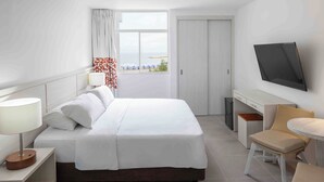 Ein Hotelzimmer mit Bett, Schreibtisch, Stuhl, Fernseher und Fenster mit Blick.