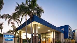 A Travelodge by Wyndham Inn & Suites with a modern design, featuring a covered entrance and palm trees. - Travelodge Inn & Suites by Wyndham Anaheim on Disneyland Dr (Anaheim)