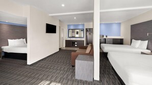 A modern hotel room with two single beds, a sofa, a desk, and a TV. - Travelodge Inn & Suites by Wyndham Anaheim on Disneyland Dr (Anaheim)