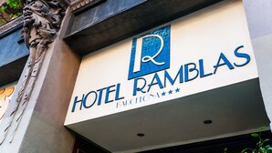 Letrero de hotel con el nombre 'HOTEL RAMBLAS' y la palabra 'BARCELONA' debajo.