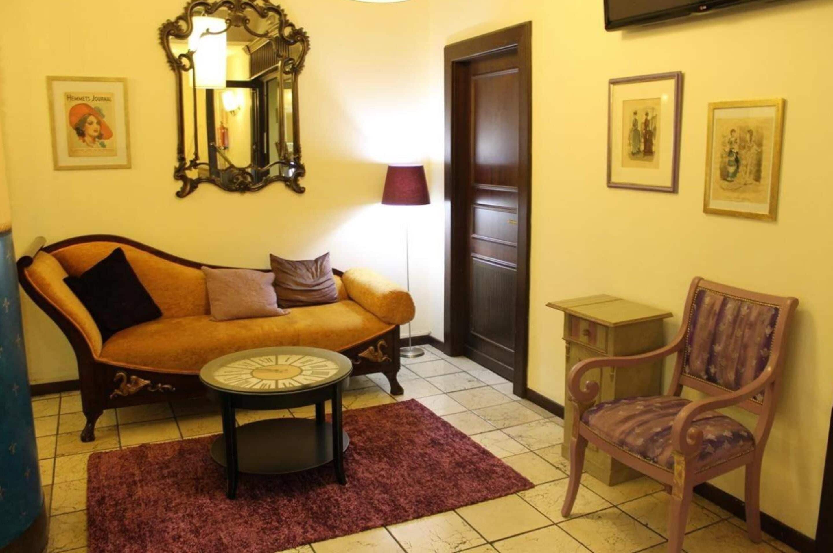 Una sala de estar acogedora con un sofá, un sillón y una mesita redonda.