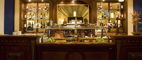 A bar area with shelves of liquor bottles, a counter with glasses, and a decorative centerpiece.