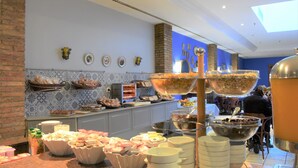 Un bufé con diferentes opciones de comida y un tazón grande en el centro.