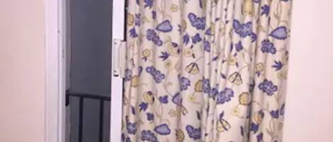 A room with a door featuring a floral curtain.