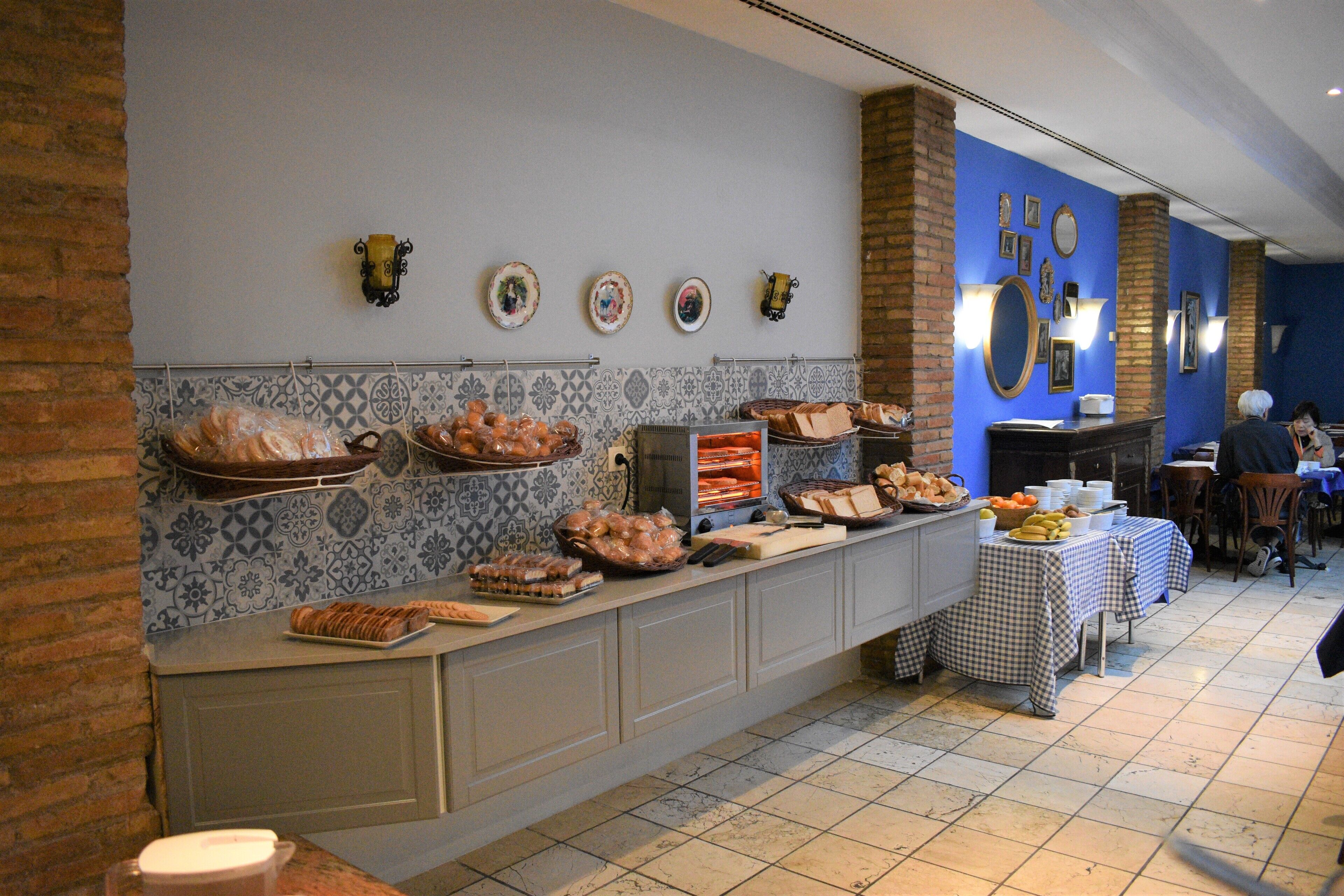 A buffet setup with various food items, a tiled backsplash, and a blue accent wall.