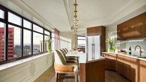 Una cocina moderna con una isla grande, armarios de madera y vistas de la ciudad a través de amplias ventanas.