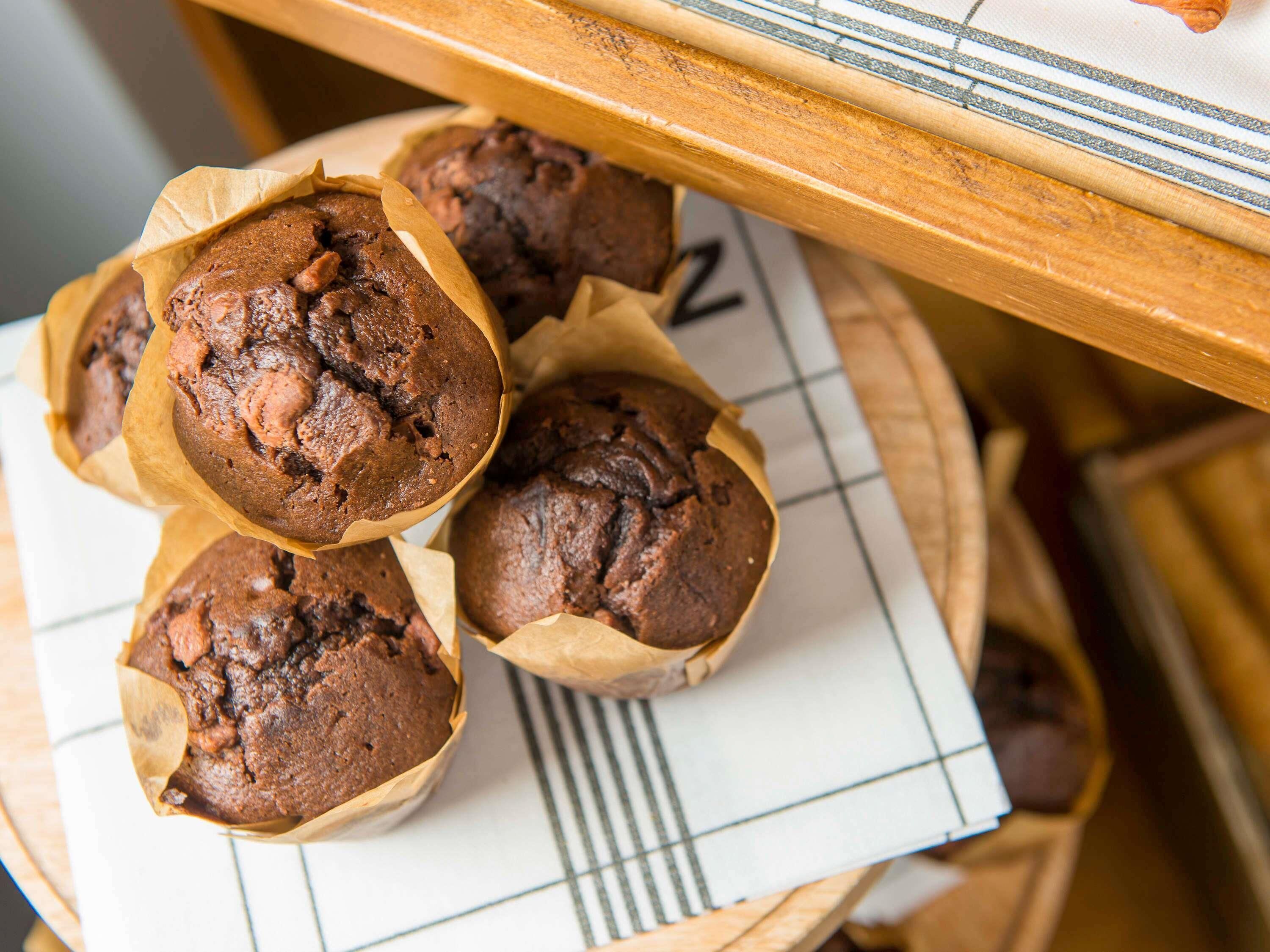 Bandeja de muffins sobre una mesa con mantel a cuadros.