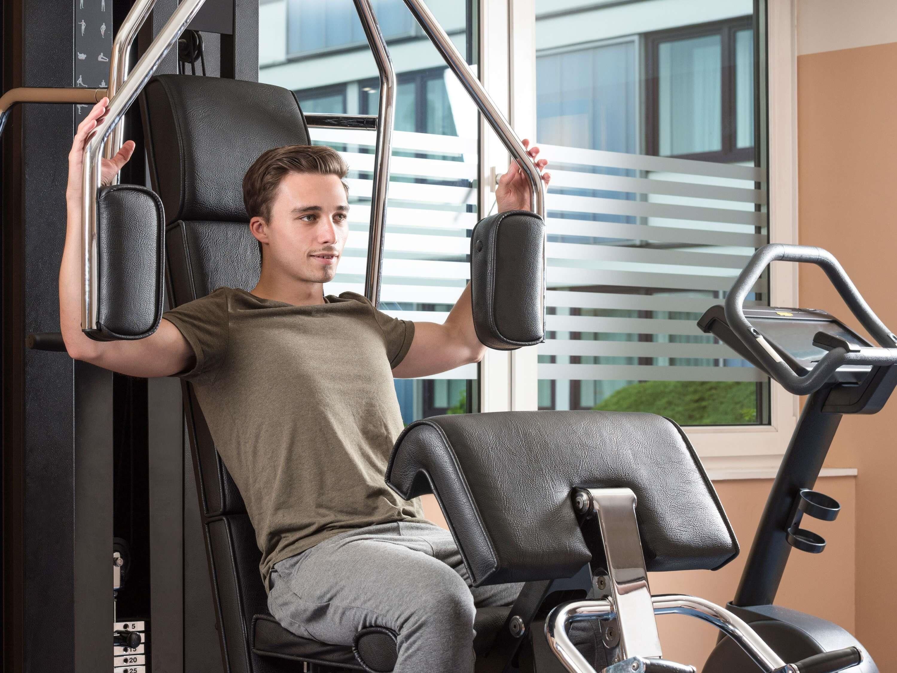 Una persona usando una máquina de gimnasio con vistas a una ventana.